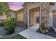 Charming stone home featuring an ornate wrought iron gate, complemented by lush landscaping and a welcoming pathway at 6299 S Roanoke St, Gilbert, AZ 85298