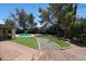 Beautiful backyard featuring lush green grass, trees, and a pool at 6911 E Thunderbird Rd, Scottsdale, AZ 85254