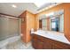 Bathroom with orange walls, updated vanity, tile floors, and shower-tub combo with a glass enclosure at 6911 E Thunderbird Rd, Scottsdale, AZ 85254