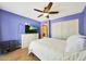 Blue bedroom with wood-look floors, ceiling fan, view to en suite bath, and chest of drawers at 6911 E Thunderbird Rd, Scottsdale, AZ 85254