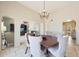 Bright dining room with decorative chandelier, arched doorways, and beige chairs at 6911 E Thunderbird Rd, Scottsdale, AZ 85254