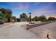 Long driveway leading up to the house featuring desert landscaping, palm trees, and a tranquil twilight sky at 6911 E Thunderbird Rd, Scottsdale, AZ 85254