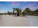 Spacious front yard with desert landscaping, mature palm trees, and a long driveway at 6911 E Thunderbird Rd, Scottsdale, AZ 85254