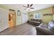 Spacious living room with light yellow walls, ceiling fan, wood-look floors, leather sofas and multiple entryways at 6911 E Thunderbird Rd, Scottsdale, AZ 85254