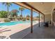 View of the kidney-shaped pool, covered patio, and lush trees in this private backyard oasis at 6931 E Pershing Ave, Scottsdale, AZ 85254
