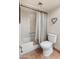 Bathroom featuring a bathtub with shower and patterned shower curtain, alongside a toilet and heart decor at 6931 E Pershing Ave, Scottsdale, AZ 85254
