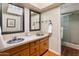 Bathroom featuring double sinks with decorative bowls, light countertops, and a glass-enclosed shower at 6931 E Pershing Ave, Scottsdale, AZ 85254
