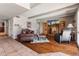 Comfortable living room with hardwood floors, stone accent wall, a leather sofa, and plentiful light, ideal for relaxation at 6931 E Pershing Ave, Scottsdale, AZ 85254