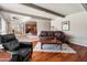 Open living area with hardwood floors, a leather sofa, and seamlessly connected dining space, perfect for entertaining at 6931 E Pershing Ave, Scottsdale, AZ 85254
