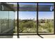 Close-up view from inside showing community greenery, mature trees and rooftops under a blue sky at 7120 E Kierland Blvd # 316, Scottsdale, AZ 85254