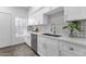 Bright and modern kitchen featuring white cabinetry, a stainless steel sink, and a tiled backsplash at 8020 E Thomas Rd # 313, Scottsdale, AZ 85251