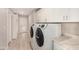 Laundry room featuring a front loading washer and dryer, white cabinets, and a countertop at 8713 E Citrus Way, Scottsdale, AZ 85250