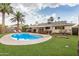 Backyard pool with artificial turf, patio seating and mature palms on a sunny day at 8713 E Citrus Way, Scottsdale, AZ 85250