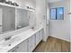 Bright bathroom with dual sinks, white cabinets, and modern fixtures at 8831 N 63Rd Dr, Glendale, AZ 85302