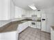Bright kitchen featuring white cabinets, appliances, and tile floors at 8831 N 63Rd Dr, Glendale, AZ 85302