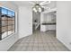 Spacious open-concept living area with a large window, ceiling fan, staircase and kitchen area with white cabinets at 8831 N 63Rd Dr, Glendale, AZ 85302