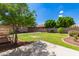 Large backyard featuring mature trees, green grass, and a concrete patio at 9 S 195Th Ln, Buckeye, AZ 85326