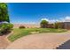 Manicured backyard with lush lawn, desert landscaping, and paver patio at 9 S 195Th Ln, Buckeye, AZ 85326