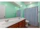 A refreshing bathroom with double sinks, a large mirror, and blue and white striped shower curtain at 9 S 195Th Ln, Buckeye, AZ 85326