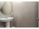 Half bathroom with pedestal sink, oval mirror, neutral walls, and tiled floors offers convenience and style at 9 S 195Th Ln, Buckeye, AZ 85326