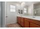 Bathroom with dual sinks, cabinetry, tile floors, a large mirror, and a separate glass-enclosed shower at 9 S 195Th Ln, Buckeye, AZ 85326