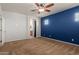 Open view from a bedroom into a bathroom with tile floors, features a carpeted floor, and a dark blue accent wall at 9 S 195Th Ln, Buckeye, AZ 85326