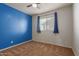Cozy bedroom featuring a ceiling fan, brown carpet, a bright accent wall, and natural light from the window at 9 S 195Th Ln, Buckeye, AZ 85326