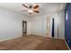 Bedroom with carpeted floors, neutral-colored walls, door leading to the bathroom with tile floor and shower at 9 S 195Th Ln, Buckeye, AZ 85326