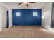 Spacious bedroom with carpeted floors, fan, neutral-colored walls, and dark blue accent wall, offering comfort and style at 9 S 195Th Ln, Buckeye, AZ 85326
