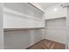 Walk-in closet with built in wooden racks and carpeted floors offers ample storage space at 9 S 195Th Ln, Buckeye, AZ 85326