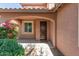Covered front entry featuring a nice dark wooden door, front window, and well-manicured landscaping at 9 S 195Th Ln, Buckeye, AZ 85326