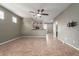 Open-concept living room with a ceiling fan, neutral walls, and tan tile flooring at 9 S 195Th Ln, Buckeye, AZ 85326