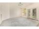 Bright living room features plush carpeting, neutral paint, and access to the outdoors at 941 N Benson Ln, Chandler, AZ 85224