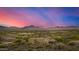 Scenic aerial view of desert homes nestled in a valley with beautiful mountain views at sunset with colorful skies at 11124 N 138Th Way, Scottsdale, AZ 85259