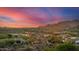 Expansive sunset view of a desert community with homes and mountains, showcasing the serene landscape at 11124 N 138Th Way, Scottsdale, AZ 85259
