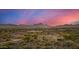 Scenic aerial view of desert homes nestled in a valley with beautiful mountain views at sunset with colorful skies at 11124 N 138Th Way, Scottsdale, AZ 85259