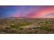 Scenic aerial view of desert homes nestled in a valley with beautiful mountain views at sunset with colorful skies at 11124 N 138Th Way, Scottsdale, AZ 85259