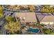 Aerial shot displaying a backyard oasis complete with pool, waterfall features, hot tub, covered patio, and desert landscaping at 11124 N 138Th Way, Scottsdale, AZ 85259