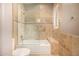 Bathroom featuring tiled shower, stone accent tiles, glass shower door and tiled tub at 11124 N 138Th Way, Scottsdale, AZ 85259