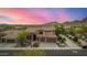Aerial view of two-story home with desert landscaping, three-car garage and mountain views in the background at 11124 N 138Th Way, Scottsdale, AZ 85259
