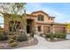 Inviting two-story desert home showcasing an arched entry, three-car garage, desert landscaping, and desert plants at 11124 N 138Th Way, Scottsdale, AZ 85259