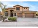 Beautiful home showcasing a three-car garage, desert landscaping, and elegant stonework at 11124 N 138Th Way, Scottsdale, AZ 85259