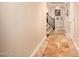 Inviting hallway with travertine tile floors, staircase, art niche, and neutral color palette at 11124 N 138Th Way, Scottsdale, AZ 85259