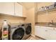 Functional laundry room equipped with modern washer and dryer, and ample storage cabinets at 11124 N 138Th Way, Scottsdale, AZ 85259