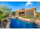 Backyard featuring a pool, hot tub and patio, with lush desert landscaping and waterfall feature at 11124 N 138Th Way, Scottsdale, AZ 85259