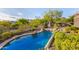 Stunning pool with rock waterfall feature, surrounded by lush desert landscaping and mountain views at 11124 N 138Th Way, Scottsdale, AZ 85259