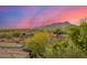 Rear exterior of desert home with mountain views in the background at sunset at 11124 N 138Th Way, Scottsdale, AZ 85259
