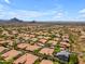 Stunning aerial view of a neighborhood with tile roofs and desert landscaping against a backdrop of mountains and blue sky at 12605 E Kalil Dr, Scottsdale, AZ 85259