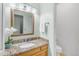 This half bathroom offers a granite-topped vanity, framed mirror, and natural light at 12605 E Kalil Dr, Scottsdale, AZ 85259