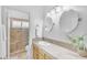 Bright bathroom with neutral tile, a glass shower door, double sinks, and granite countertops at 12605 E Kalil Dr, Scottsdale, AZ 85259